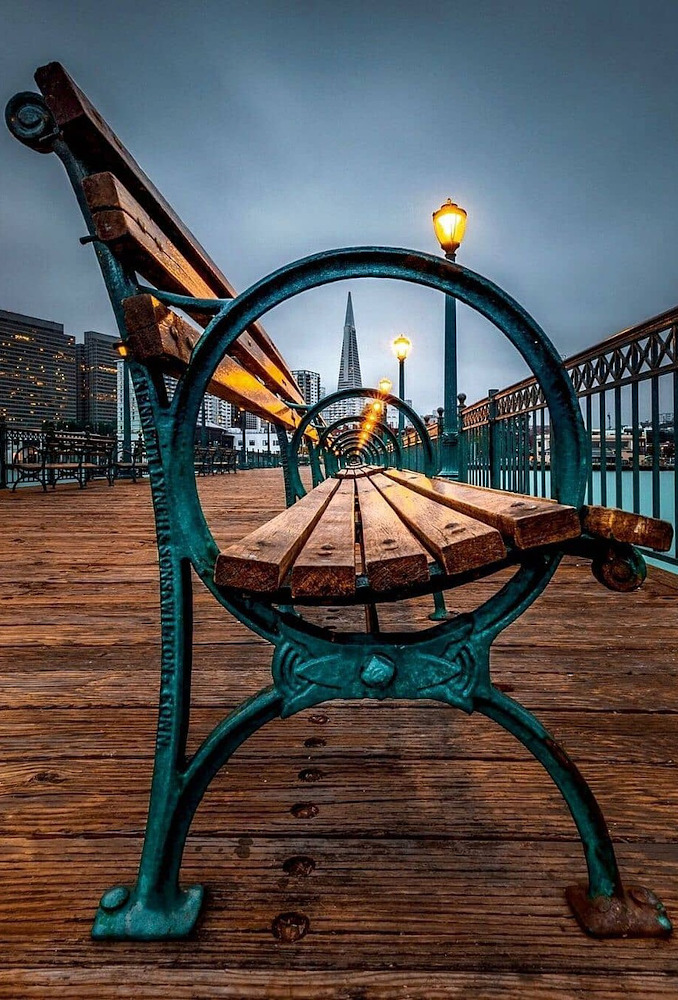 Side view of wrought-iron bench on a pier.