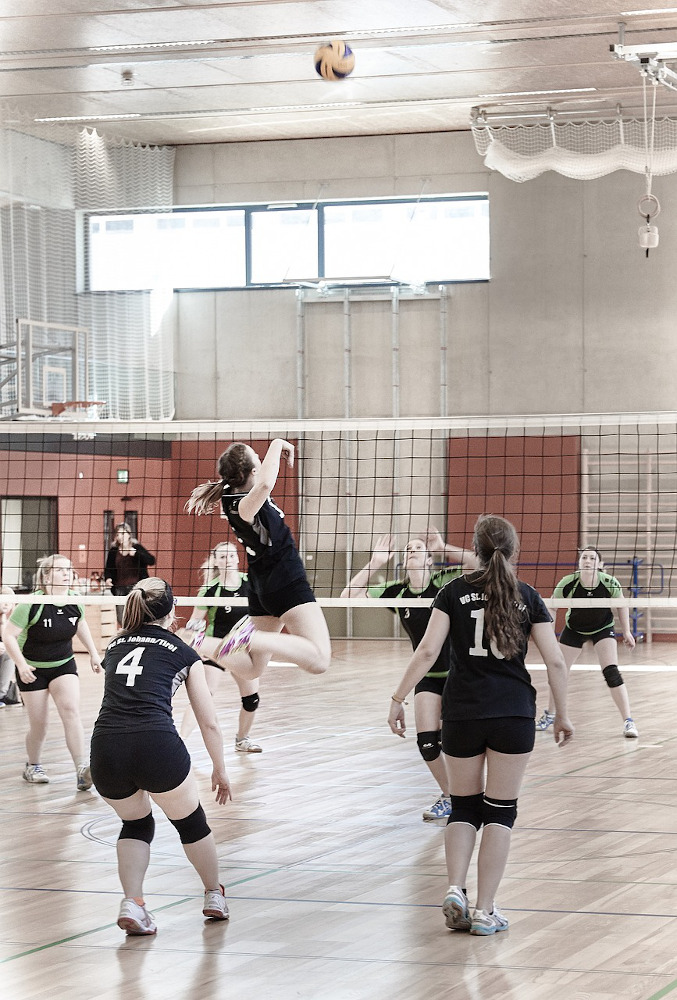 Girls playing volleyball indoors