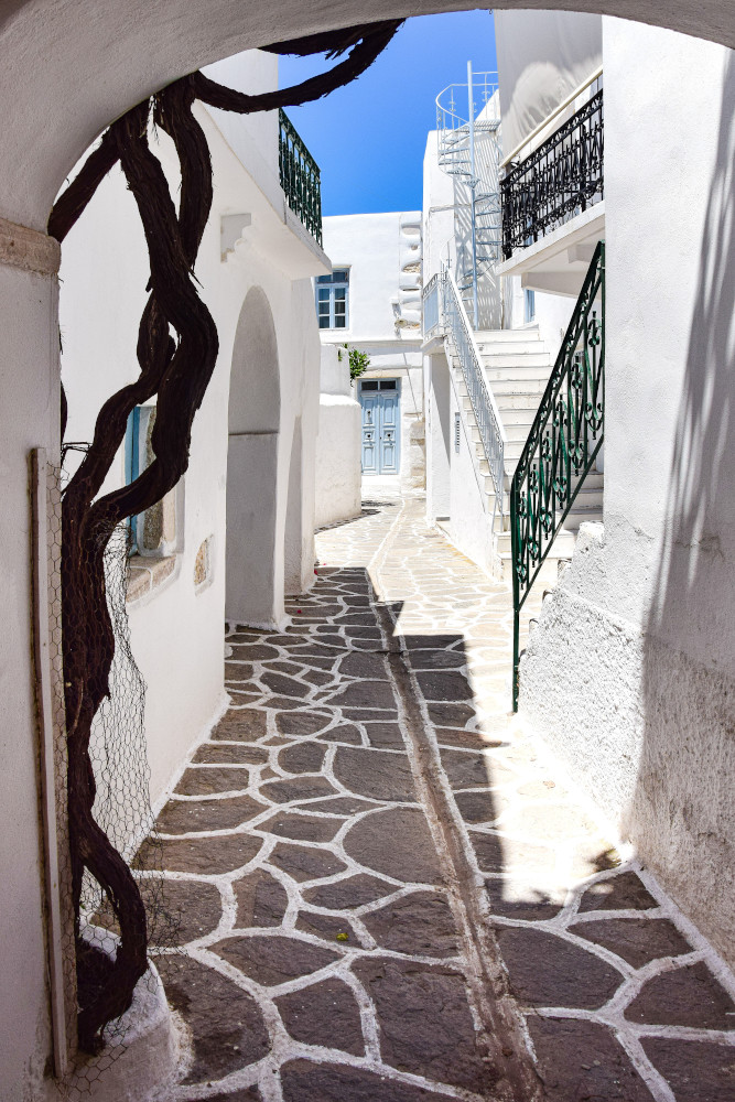 Narrow street with white-walled buildings and blue sky